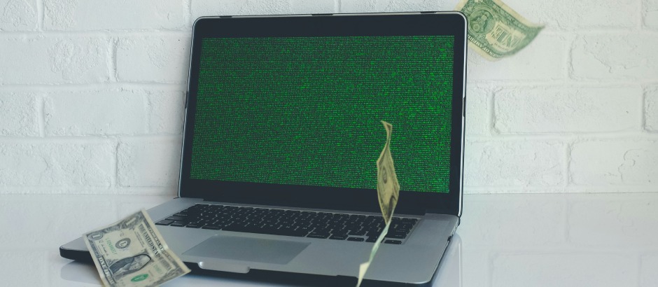 Is e-commerce nog winstgevend? Ontdek de online verdienmogelijkheden Laptop waar dollarbiljetten omheen dwarrelen, symbool voor online inkomsten uit e-commerce